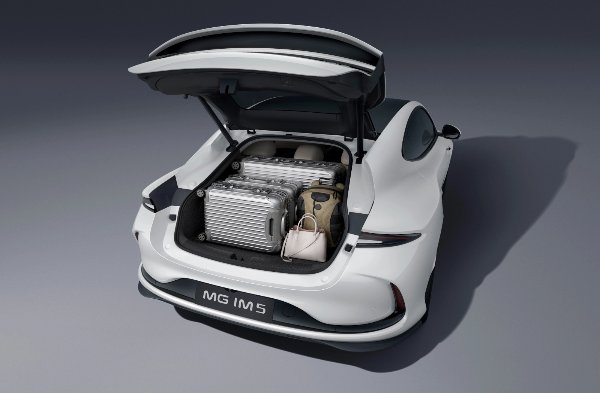 White MG IM5 car boot open, showing luggage and bags inside.