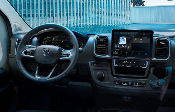 Van interior showing a steering wheel and digital dashboard display screen.