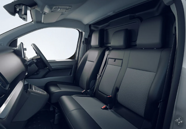 Van interior with black seats and dashboard, showing steering wheel and console.