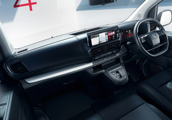 Car interior showing steering wheel and dashboard with integrated display.