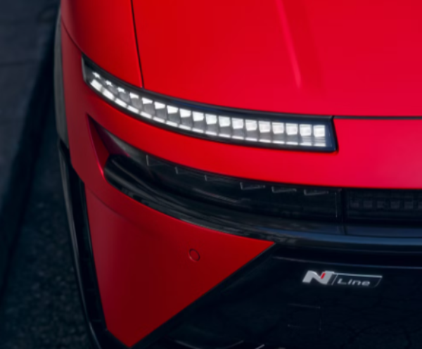 Close-up of a red car's front, showing LED headlights and an N Line badge.