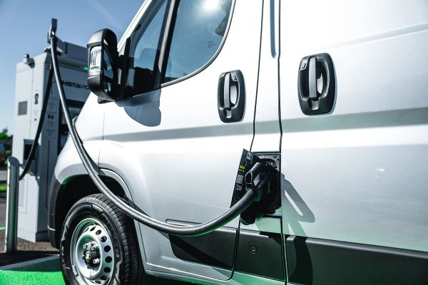 Electric van charging at a charging station.