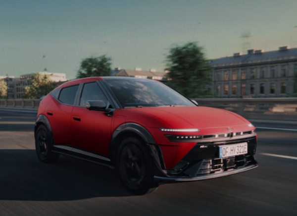 Red electric SUV driving on a city road.