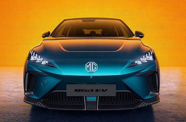 Front view of teal MG4 electric vehicle with illuminated headlights.