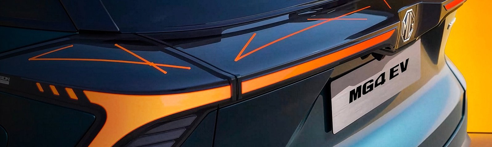 Close-up of MG4 EV car's rear with orange accents, featuring its nameplate.