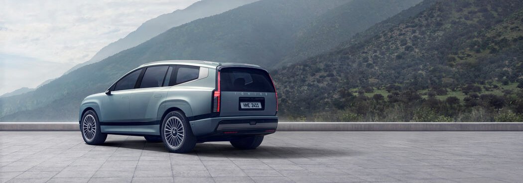 Silver SUV parked with mountain landscape in the background.