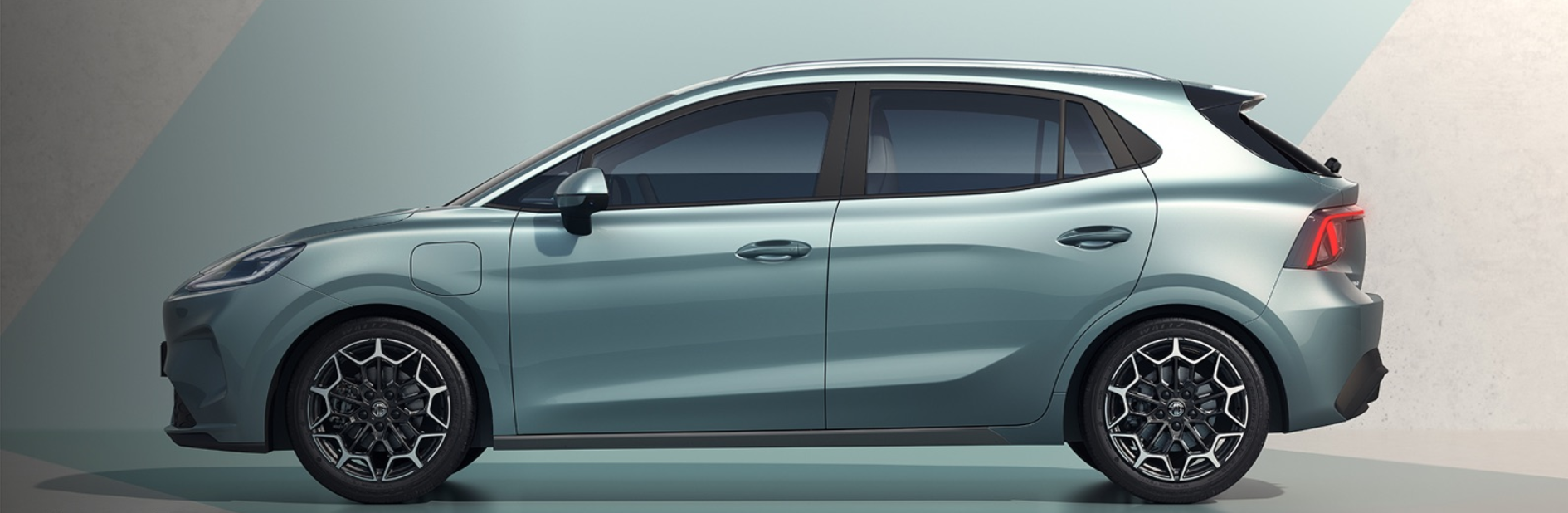 Side profile of a metallic light blue hatchback car with black alloy wheels.