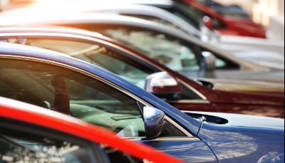 Line of parked cars in various colours seen from the side.